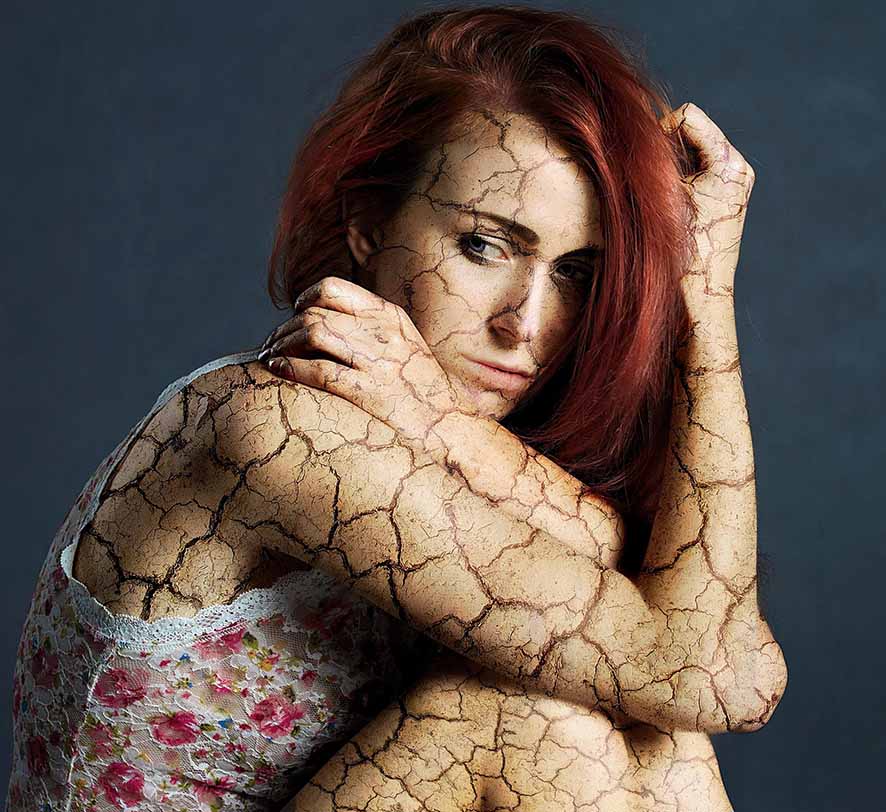 Autocuidado emocional y el precio de no parar Retrato artístico de una mujer con la piel agrietada que representa el agotamiento y la desconexión del autocuidado emocional
